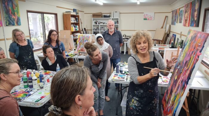 Professional art instructor Leonie Brown providing personalized student feedback at LifeArt School studio.